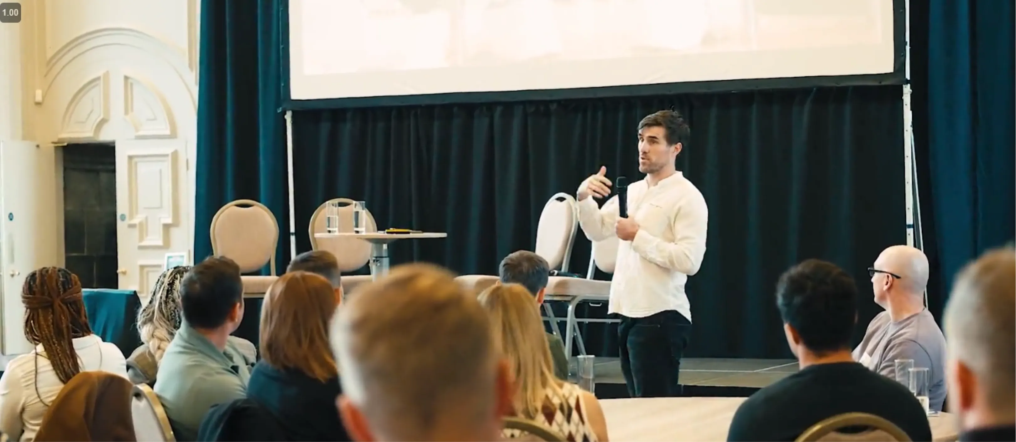 Ronan Conway speaking to a seated audience at a conference